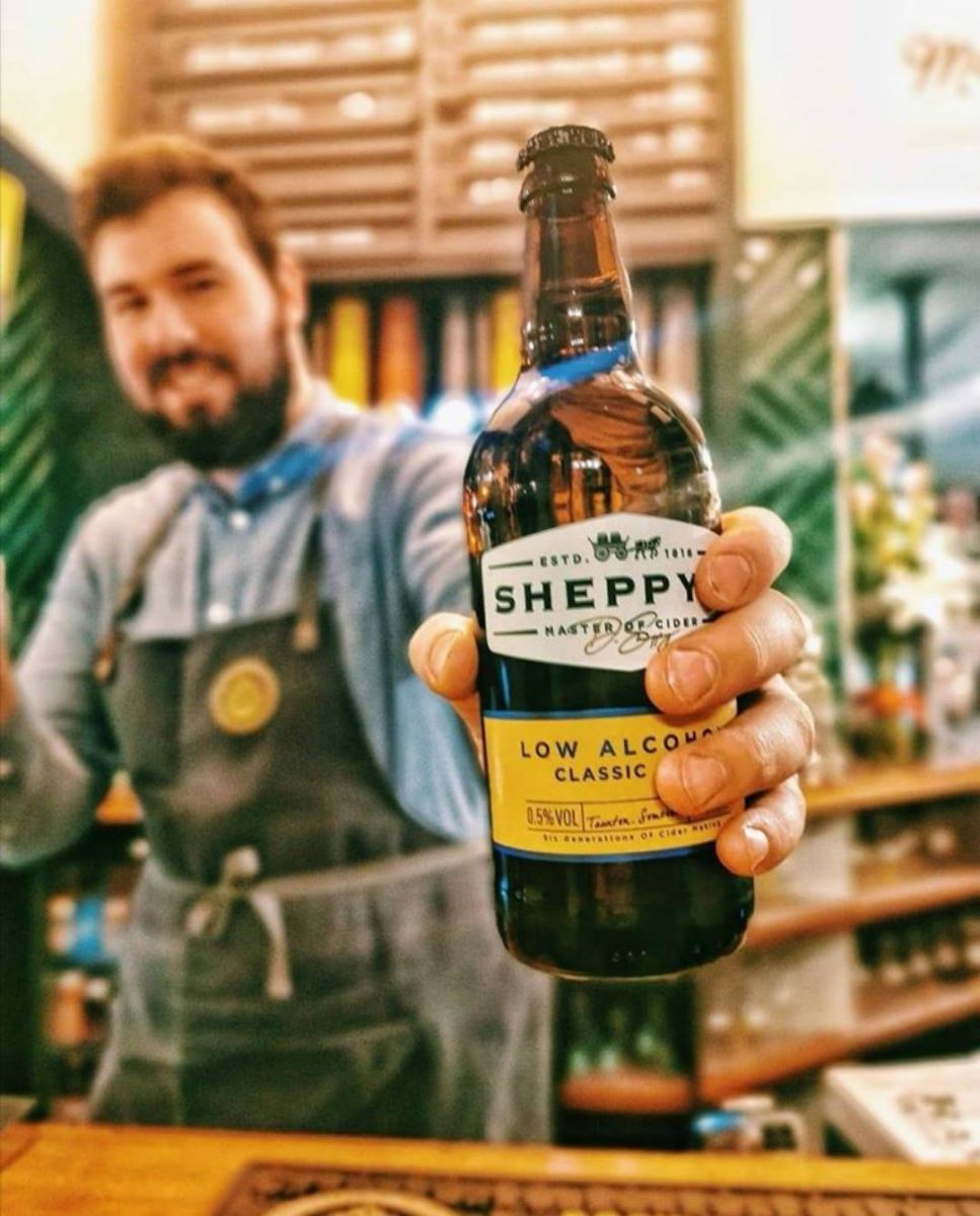 A bartender in the Bournemouth branch of Brewhouse and Kitchen holding a Sheppy low-alcohol beer.